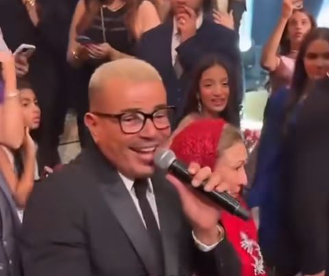 سيدة مسنة ترقص مع عمرو دياب وتقبل يده