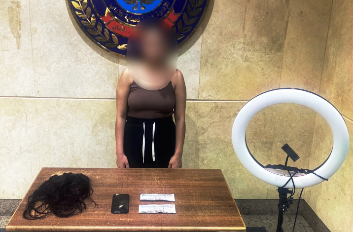 المتهمة و أمامها المضبوطات