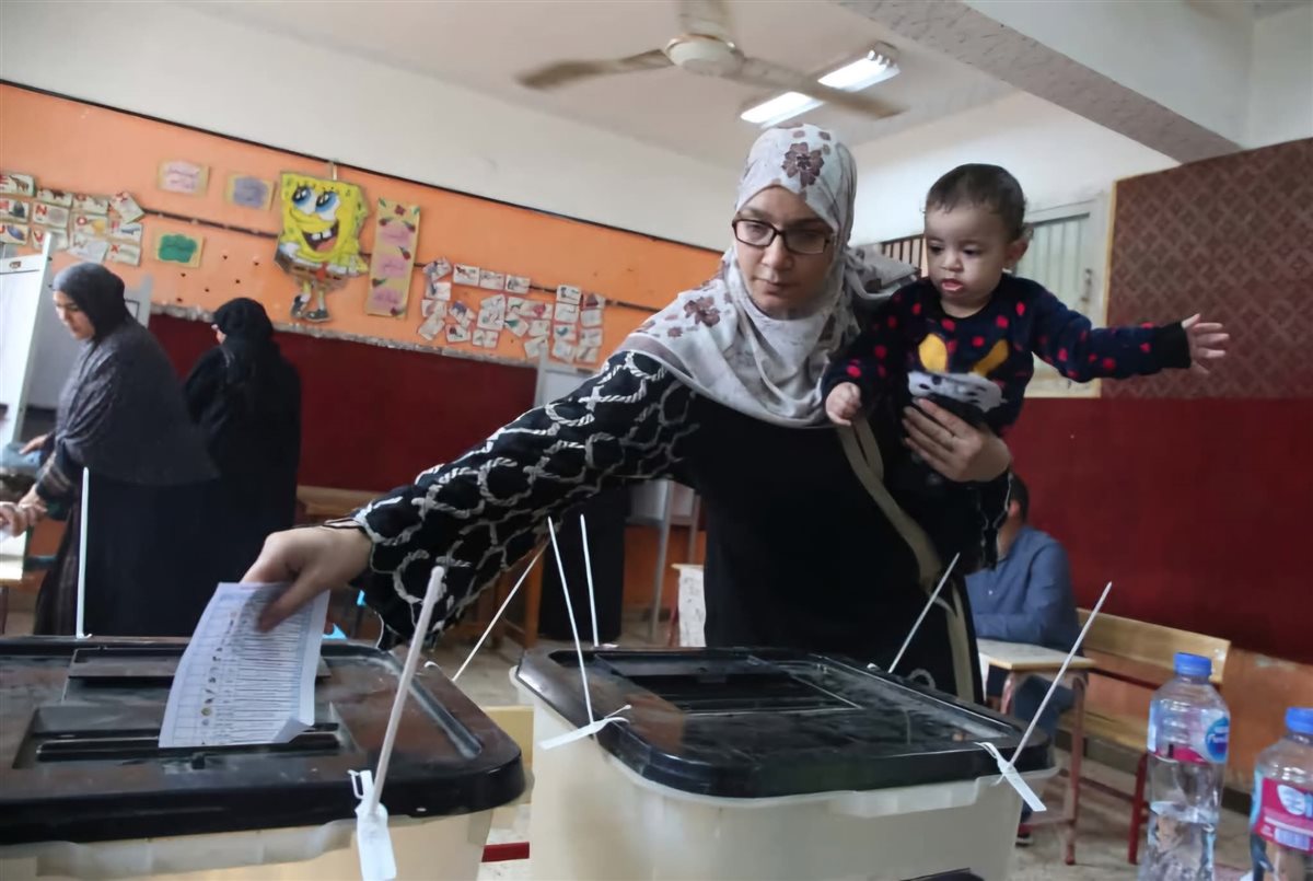 أم تحمل طفلها تدلى بصوتها