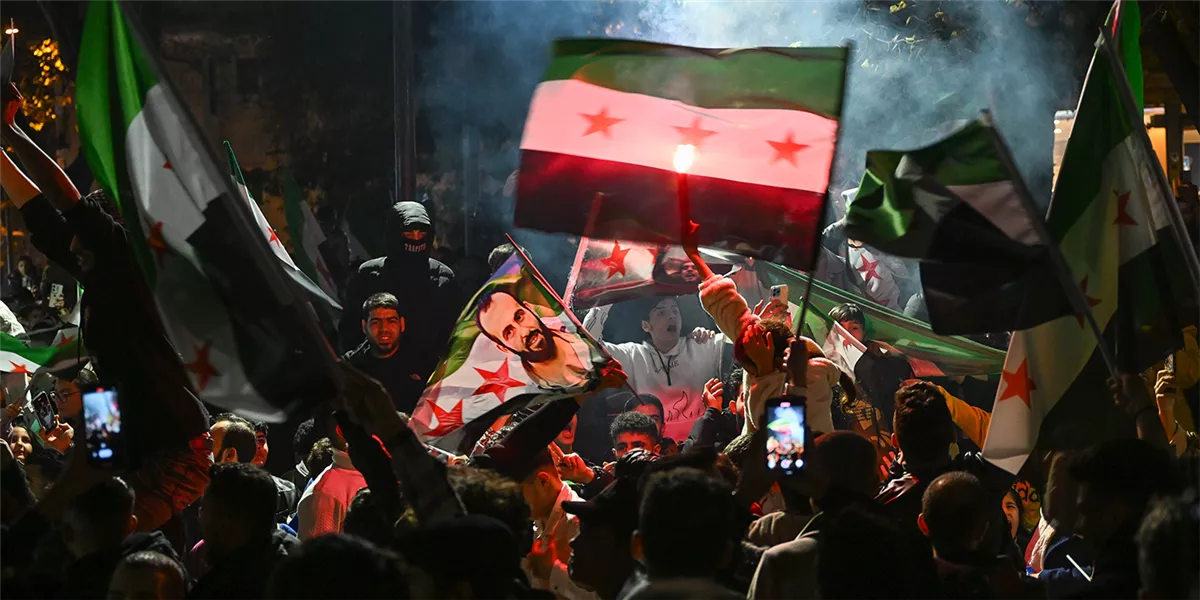 متظاهرون يرفعون علم الثورة السورية عقب سقوط نظام الأسد