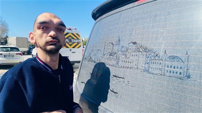 رسام يتحدى الإعاقة.. لوحات إسطنبول على سيارات مغبرة