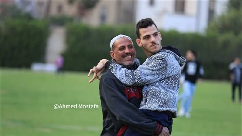 أب يحمل إبنه لمساندة