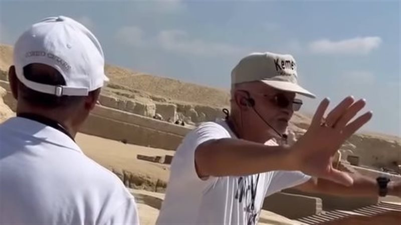 أجنبي يشرح أمام الأهرامات